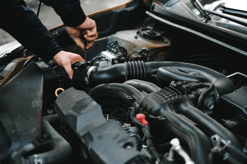 Hands working on a vehicle engine